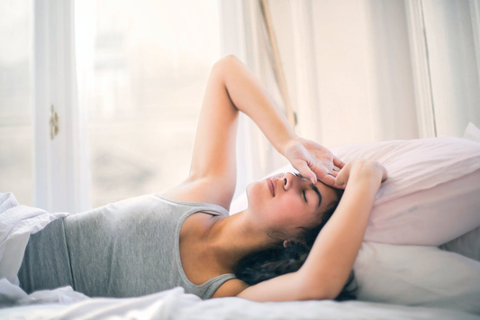 A Woman in a Gray Tank Top, Half Asleep in Bed