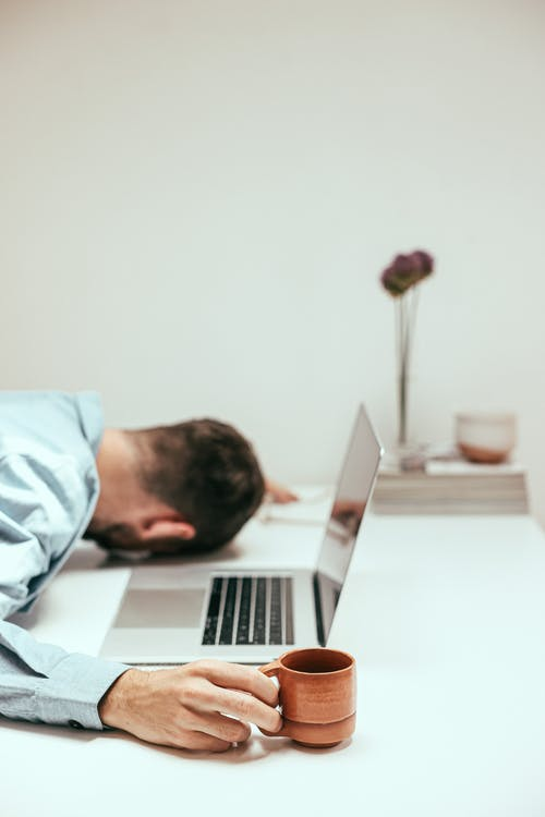 A person at a desk, feeling tired