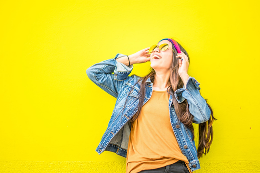Happy woman against a yellow wall.