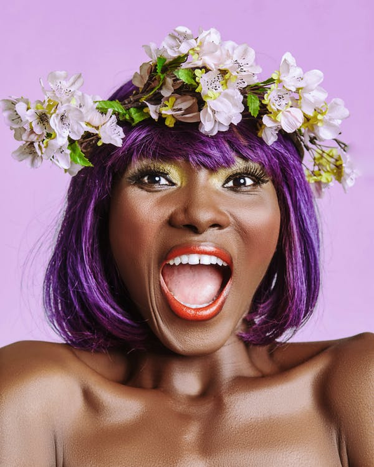 An African-American Woman with Mouth Wide Open and Sporting Purple Hair Adorned with a Flower Crown