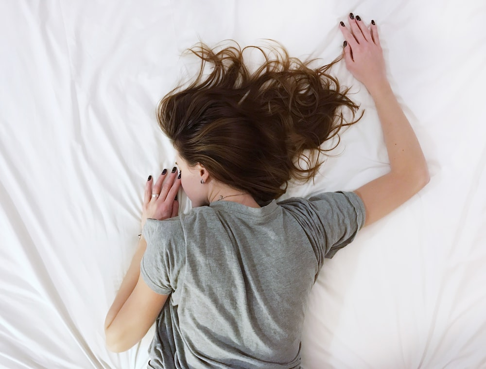 A person feeling tired, lying in bed