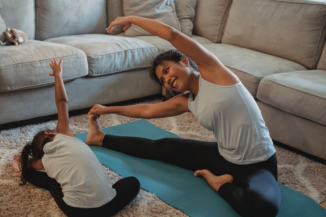 A mother showing her daughter how to do stretches