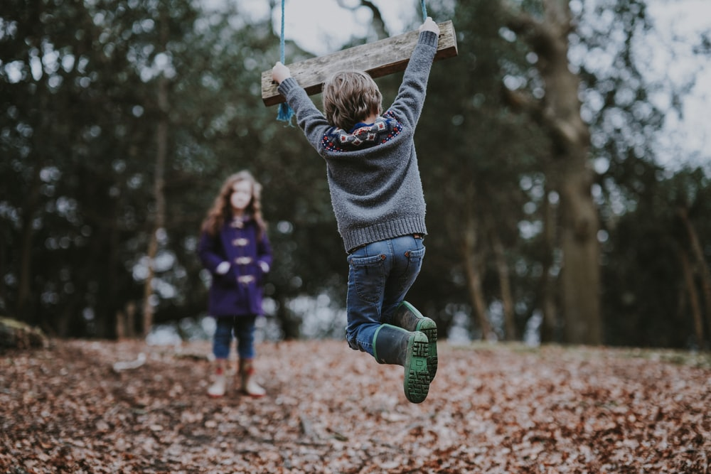 Children playing on swings in the woods